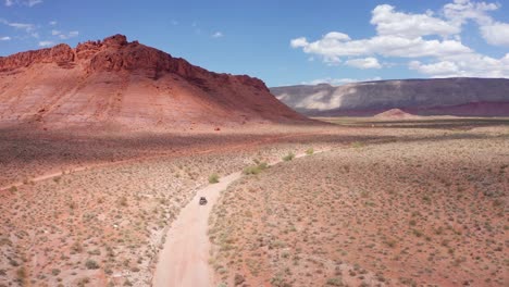 estableciendo una toma amplia del huracán, utah, con un buggy conduciendo por un camino de tierra establecido.