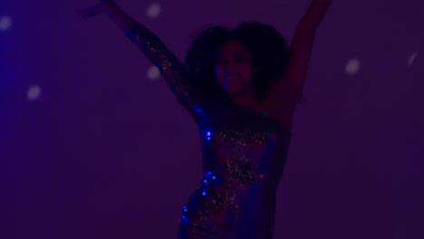 primer plano de una mujer joven en un bar nocturno o discoteca bailando con luces brillantes 9