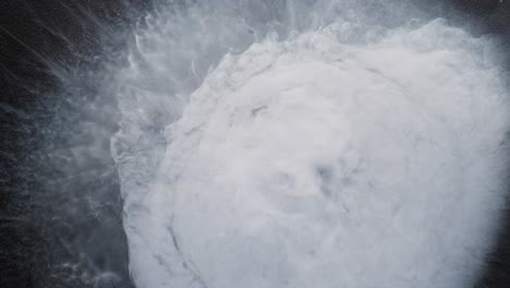 exploding white alcoholic ink creates dynamic splash pattern in abstract macro view