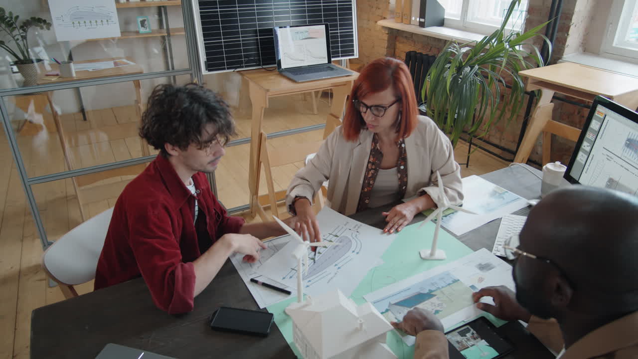 equipo de ingenieros multiétnicos discutiendo un proyecto de energía renovable