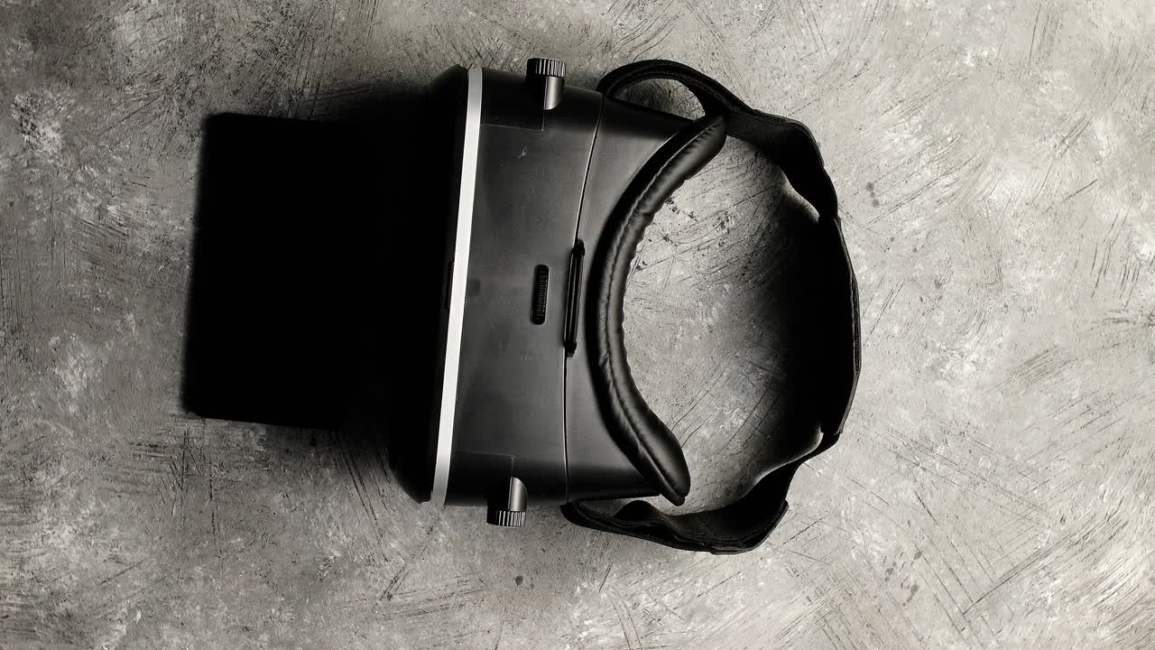 Visore VR e telefono su superficie grigia