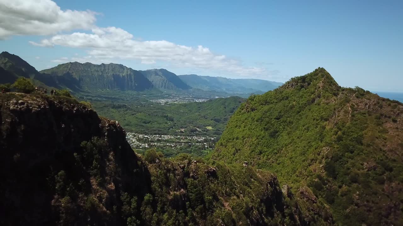 하와이 오아후의 3개 봉우리 트레일 끝에서 등산객 주변을 돌고 있는 드론 샷