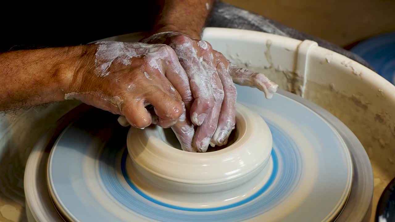도공의 손 모양과 회전하는 바퀴에 점토를 성형 닫습니다