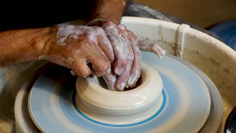 Close-up-of-the-potter's-hand-shaping-and-molding-clay-on-a-turning-wheel-