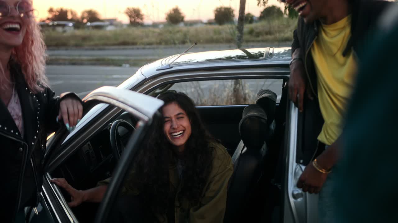 jóvenes riendo en el estacionamiento junto al coche