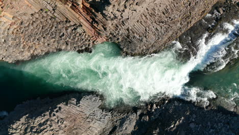 Overhead-view-rough-glacier-water-flowing-in-Stuolagil-canyon-with-basalt-volcanic-rock-formations.-Top-down-view-Jokulsa-stream-in-Vatnajokull-national-park,-Iceland-highlands