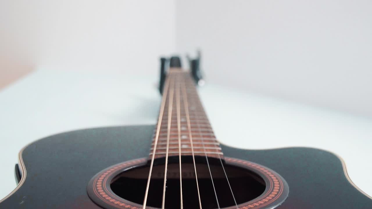 Cinematic shot of an acoustic guitar hanging on the wall