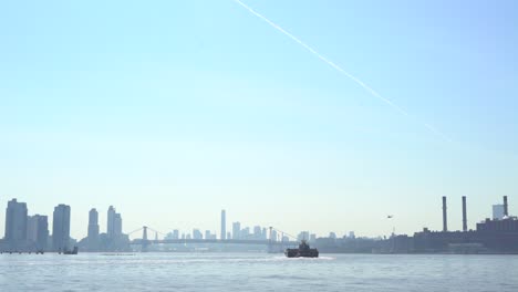 williamsburg bridge in the distance with a helicopter and boat in view