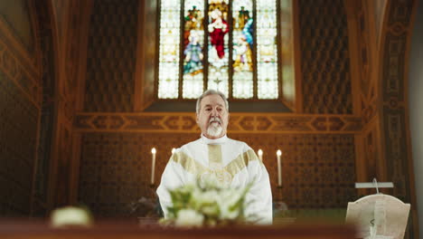 funeral, church and priest praying by coffin