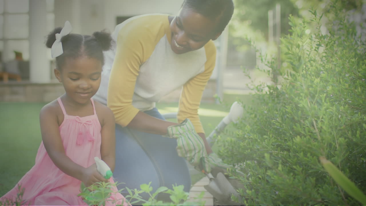 Spot of light against african american mother and daughter gardening together in the garden