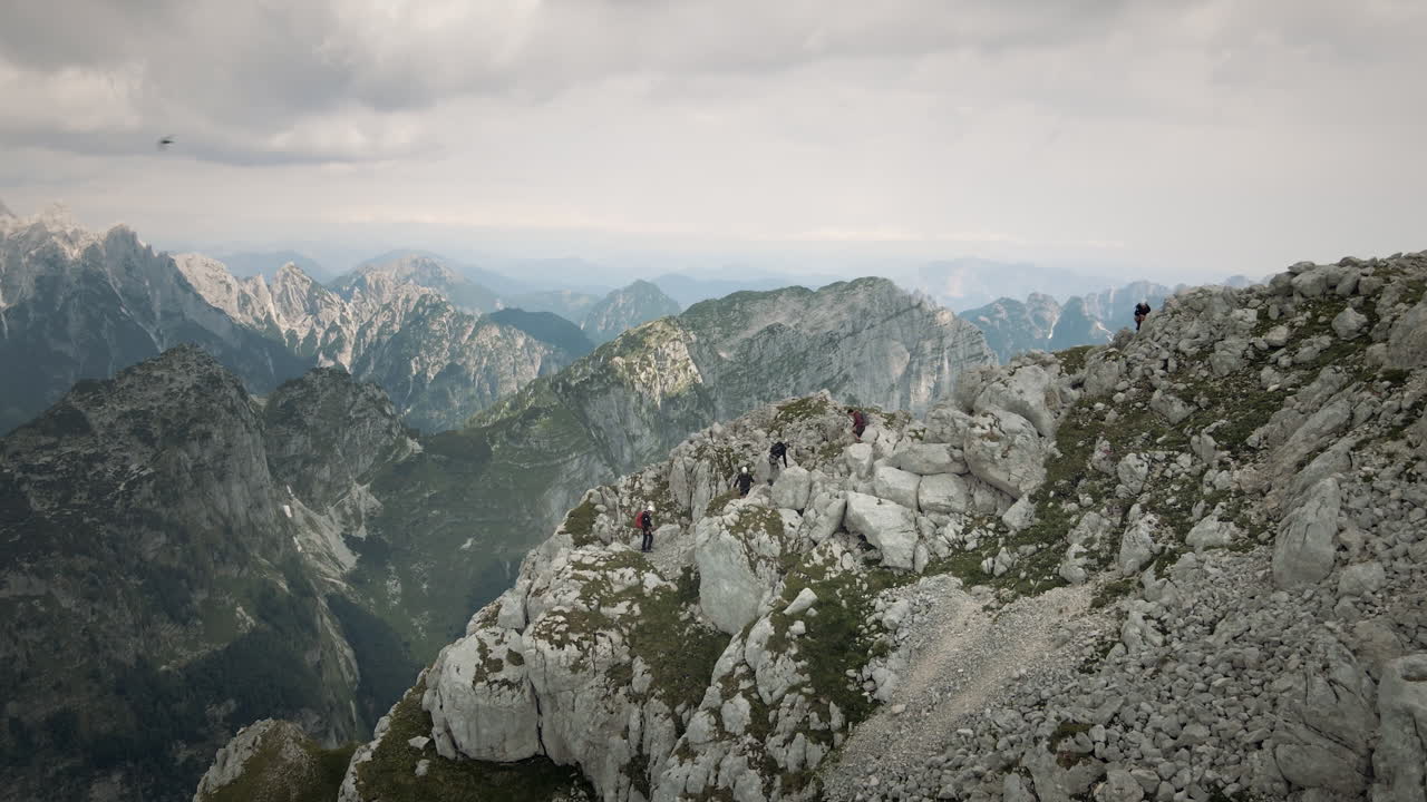 Ripresa con drone del monte Rombon e delle montagne vicine, un gruppo di escursionisti che sale su una collina per raggiungere la cima.