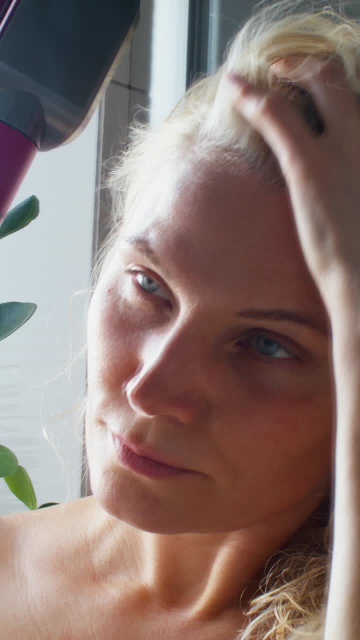 una mujer secándose el cabello.