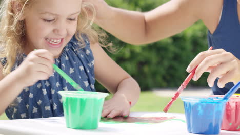 happy family  with little girl painting in the yard