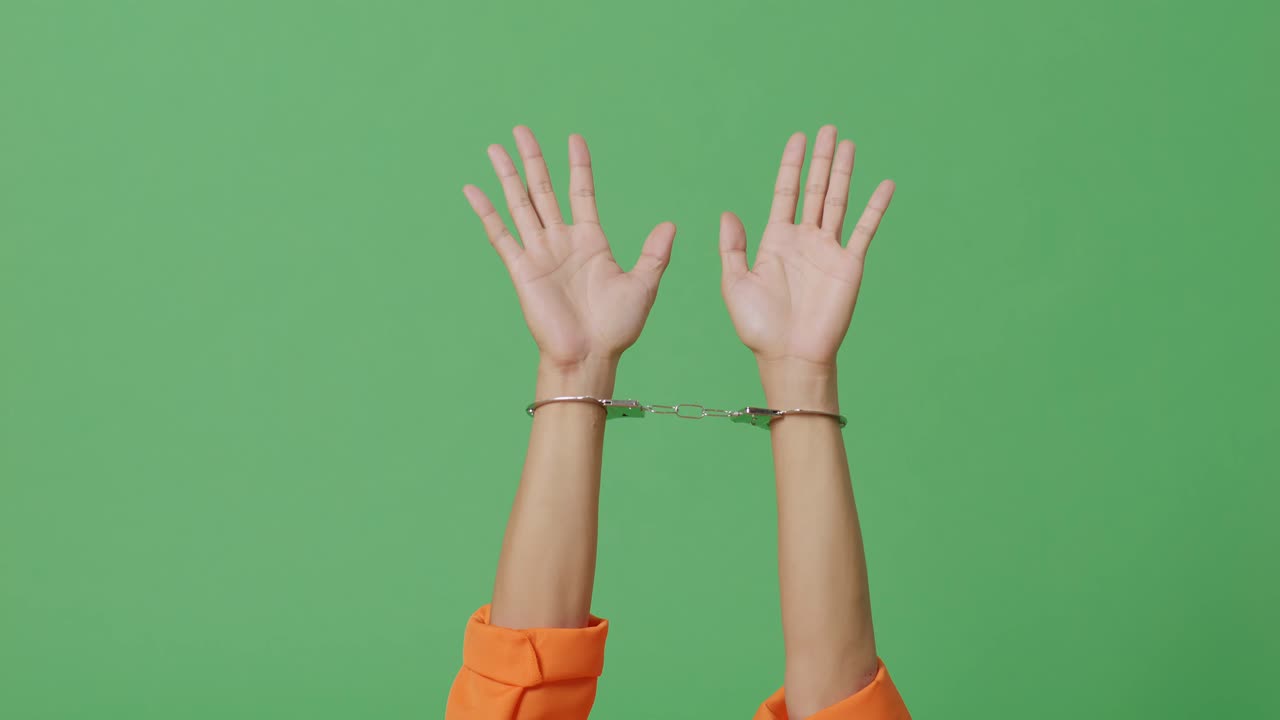 녹색 스크린 배경에 손을 은 남성 죄수의 손이 가까이 올라오고 있습니다.