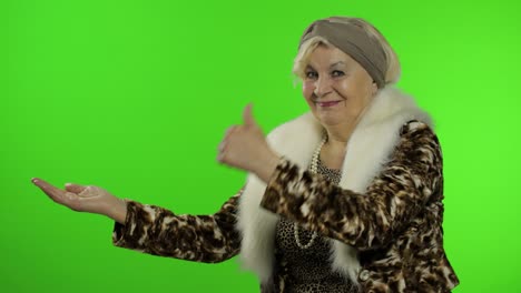 anciana abuela caucásica mujer señalando algo con la mano. llave de croma