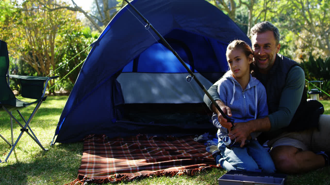 아버지 와 아들 은 텐트 밖 에서  ⁇ 시대 를 들고 있다