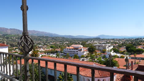 looking down on the view of spanish roof architecture and city buildings leading out to the ocean in downtown santa barbara, california