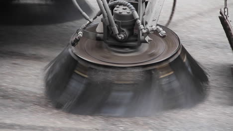 Street-sweeper-spraying-water-and-cleaning-street---Extreme-close-up