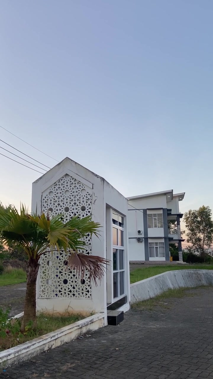 Bangunan Modern dengan Struktur Pola Geometris dan Pohon Palem