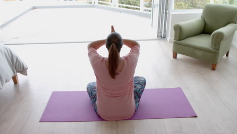 Mujer-Birracial-De-Talla-Grande-Sentada-En-El-Suelo-Practicando-Meditación-De-Yoga,-Espacio-Para-Copiar,-Cámara-Lenta