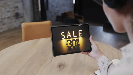 Biracial-woman-using-tablet-at-cafe-online-shopping-during-sale,-slow-motion