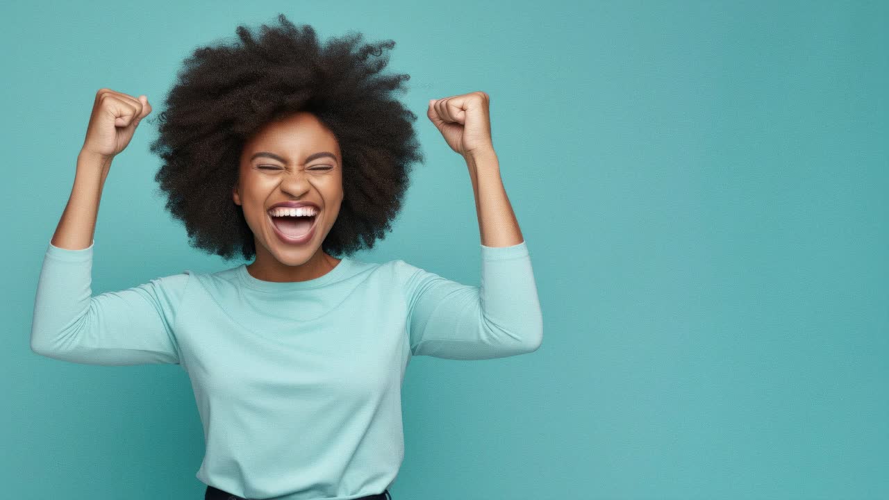 A joyful woman with raised fists, captured in a mid-shot against a teal background