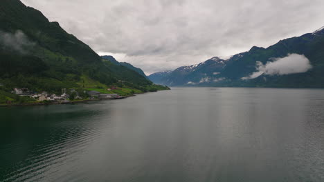 nordic fjord in beautiful aerial scene as drone follow scenic coastline with mountain backdrop