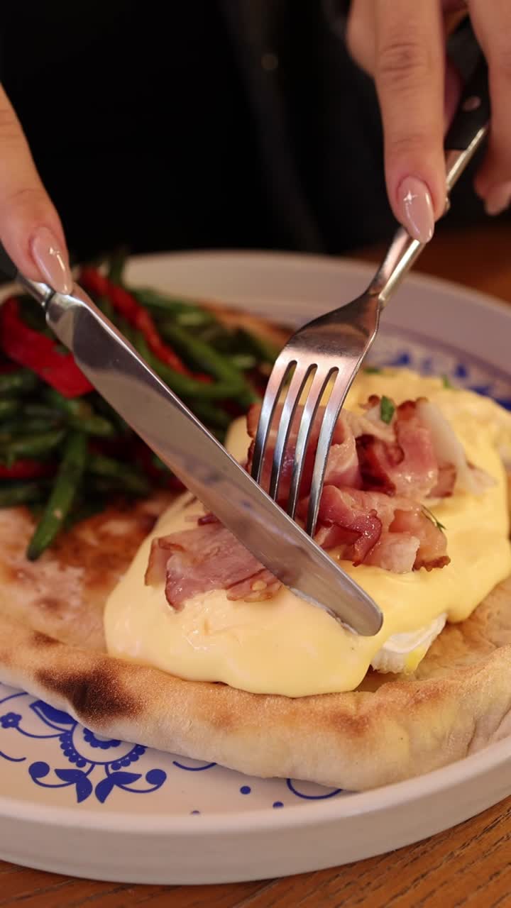 mujer comiendo huevos benedict