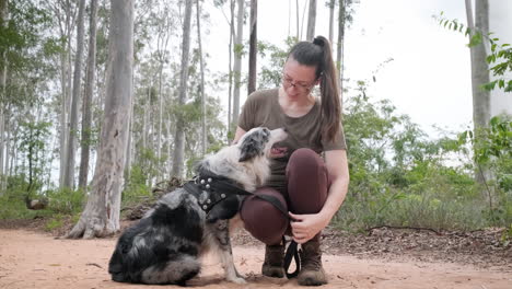 el mejor amigo del ser humano, una mujer jugando con su perro pastor australiano al aire libre.