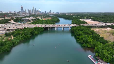 paddleboarders on colorado river with austin texas skyline panorama in distance