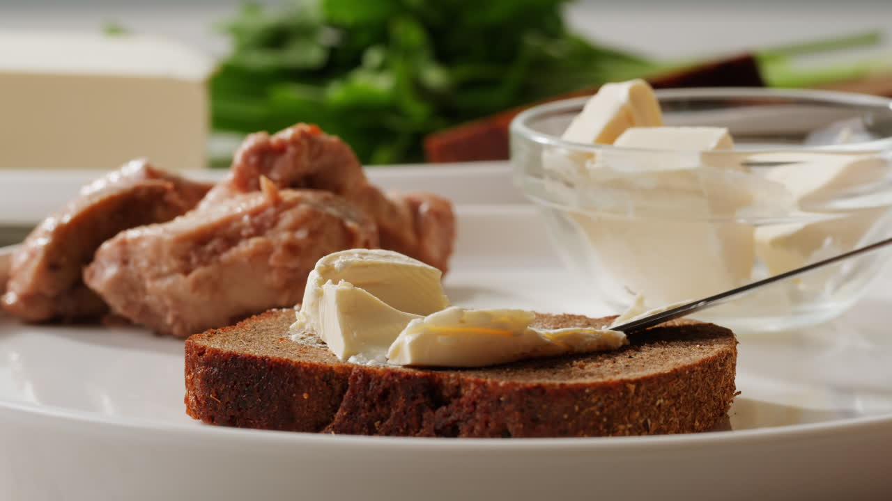 Young woman spreading nut butter onto toast in kitchen, closeup. High quality 4k footage