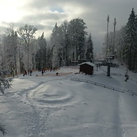 winter alpine ski resort. snow forest and skiers on a ski lift pov. aerial view