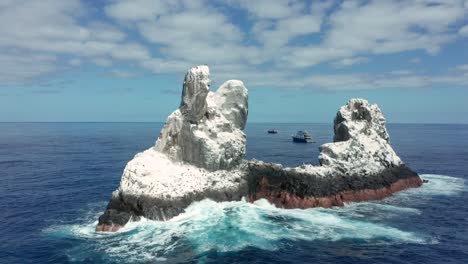 Roca-Partida-islet-in-Mexican-Pacific-surrounded-by-dive-boats,-aerial-arc