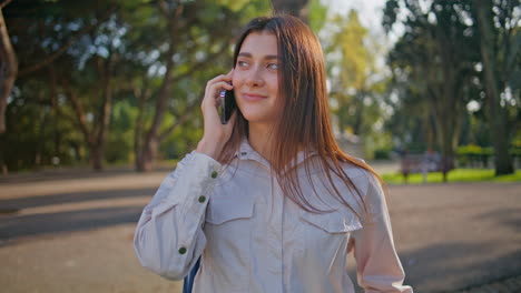 una mujer pensativa escuchando una conversación por teléfono móvil en un primer plano en green park.