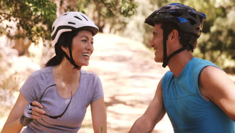 Smiling-young-couple-riding-bicycle-