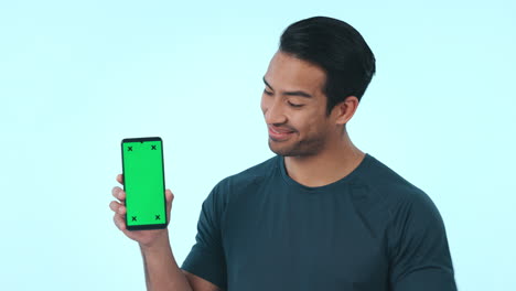 Happy-asian-man,-phone-and-pointing-to-green