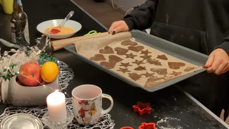 Una-Mujer-Agarra-Una-Bandeja-Con-Galletas-De-Jengibre-Cortadas-En-Lindas-Formas-Listas-Para-El-Horno