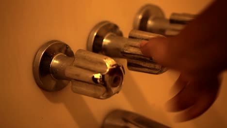 black woman hand turning shower knobs