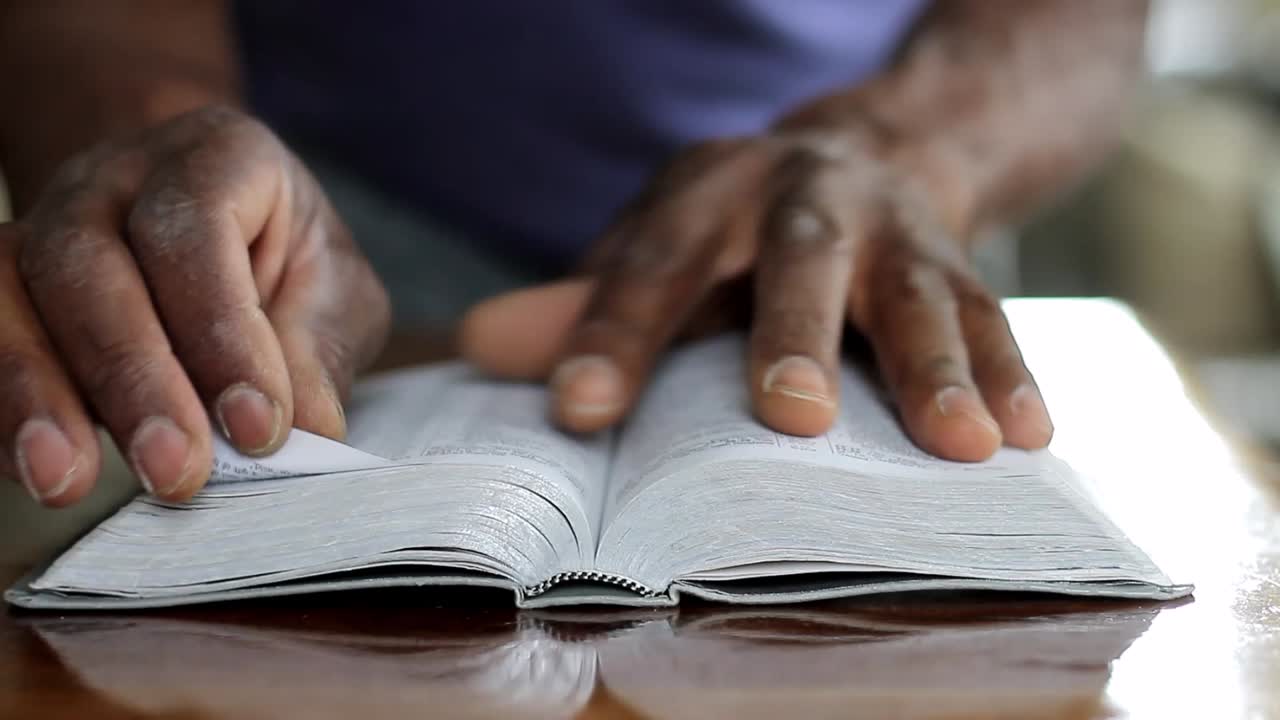 hombre orando a dios con la mano en la biblia con la gente stock video stock footage