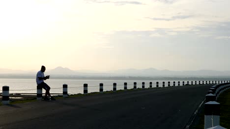 men use a smartphone taking pictures of yourself after running in the time during sunrise on dam road exercise. living healthy lifestyle concept.