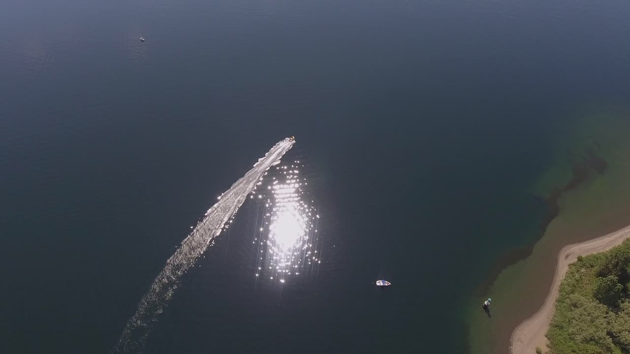 모터보트는 시원한 여름 호수의 한 지점을 돌고 있습니다.