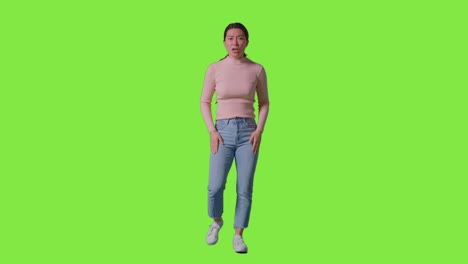 녹색 스크린 앞에 서 있는 카메라를 향해 소리치는 좌절한 분노한 여성의 전체 길이의 스튜디오 초상화 1