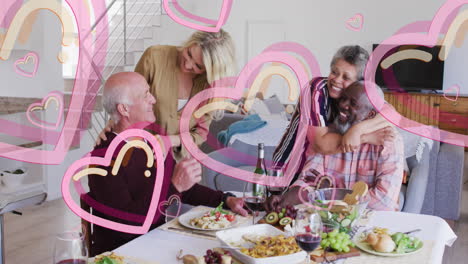 animation of heart icons over diverse group of seniors talking