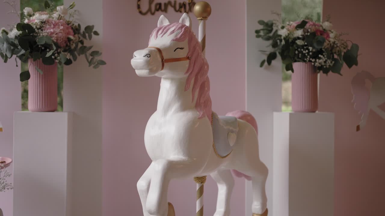 Decorative carousel horse with pink flowers indoors for event celebration