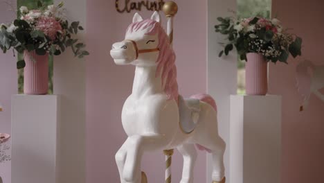decorative carousel horse with pink flowers indoors for event celebration