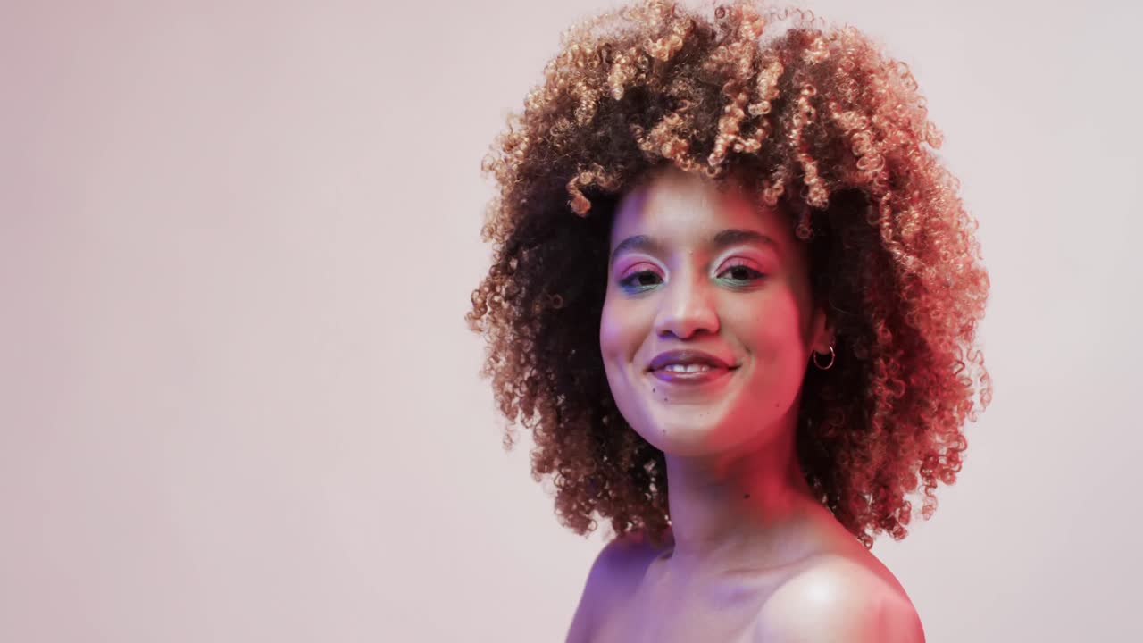 mujer biracial con cabello oscuro en luz azul y rosa con espacio de copia, cámara lenta