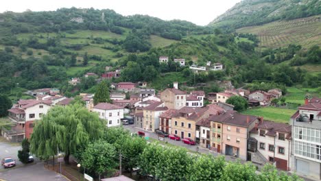 Cottages-in-a-small-village-in-a-valley-surrounded-by-green-mountains-by-day-in-northern-Spain