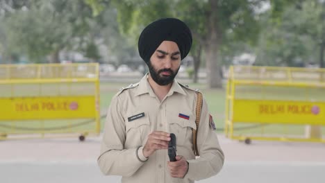 sikh indian police man checking hand gun