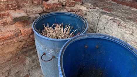 sticks being emptied from a blue bucket over time