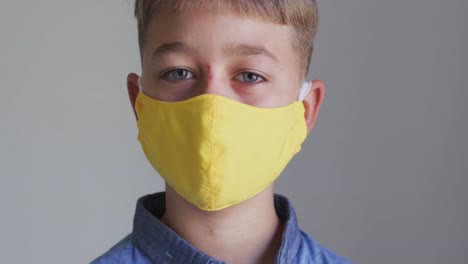 retrato de cerca de un niño caucásico poniendo una máscara de cara amarilla